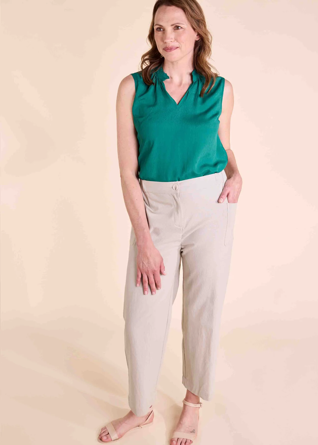 Woman wears cropped beige trousers with velcro fastening